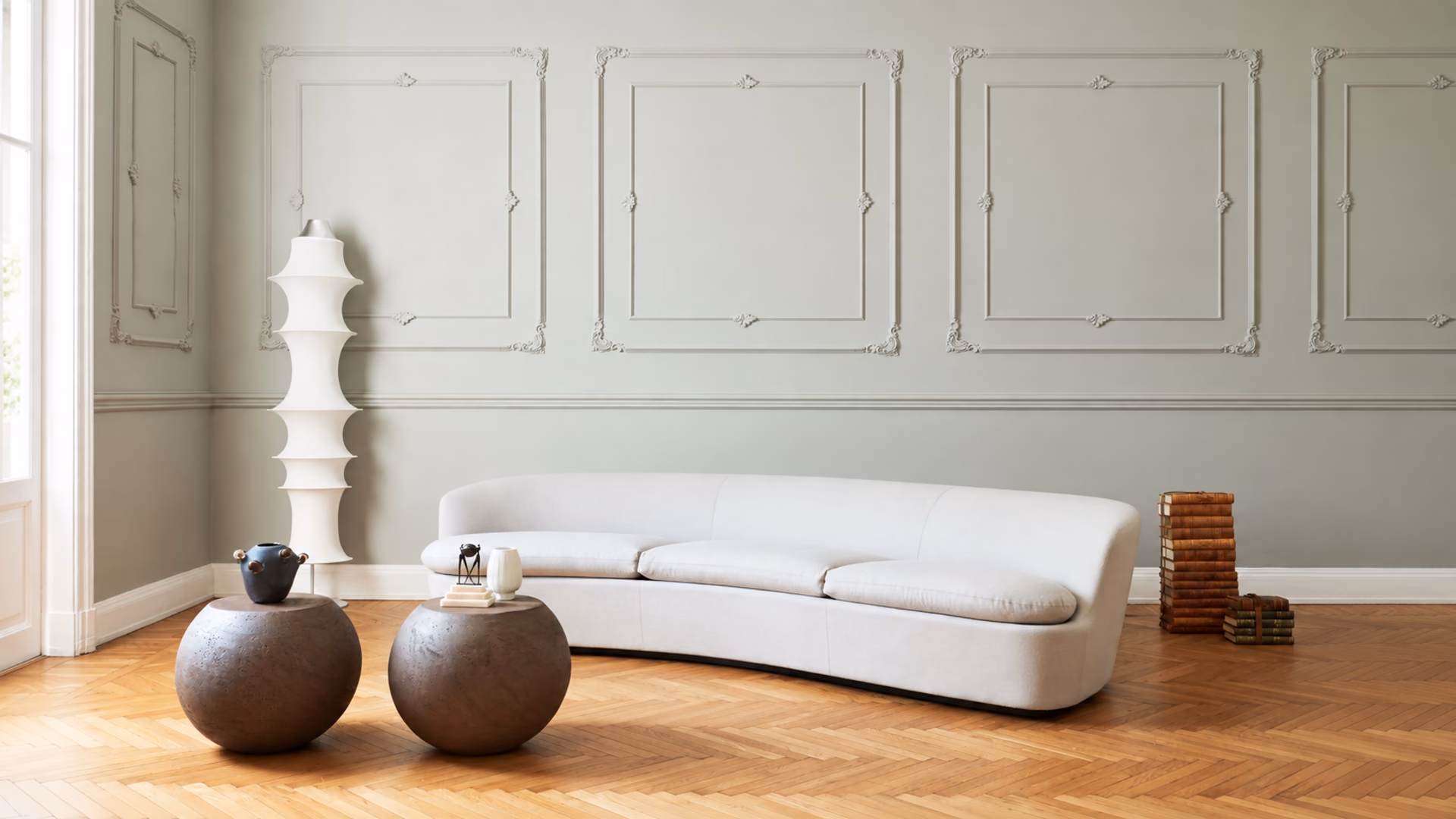 Cappellini Orla curved white sofa with rounded low tables in a room with decorative wall molding.