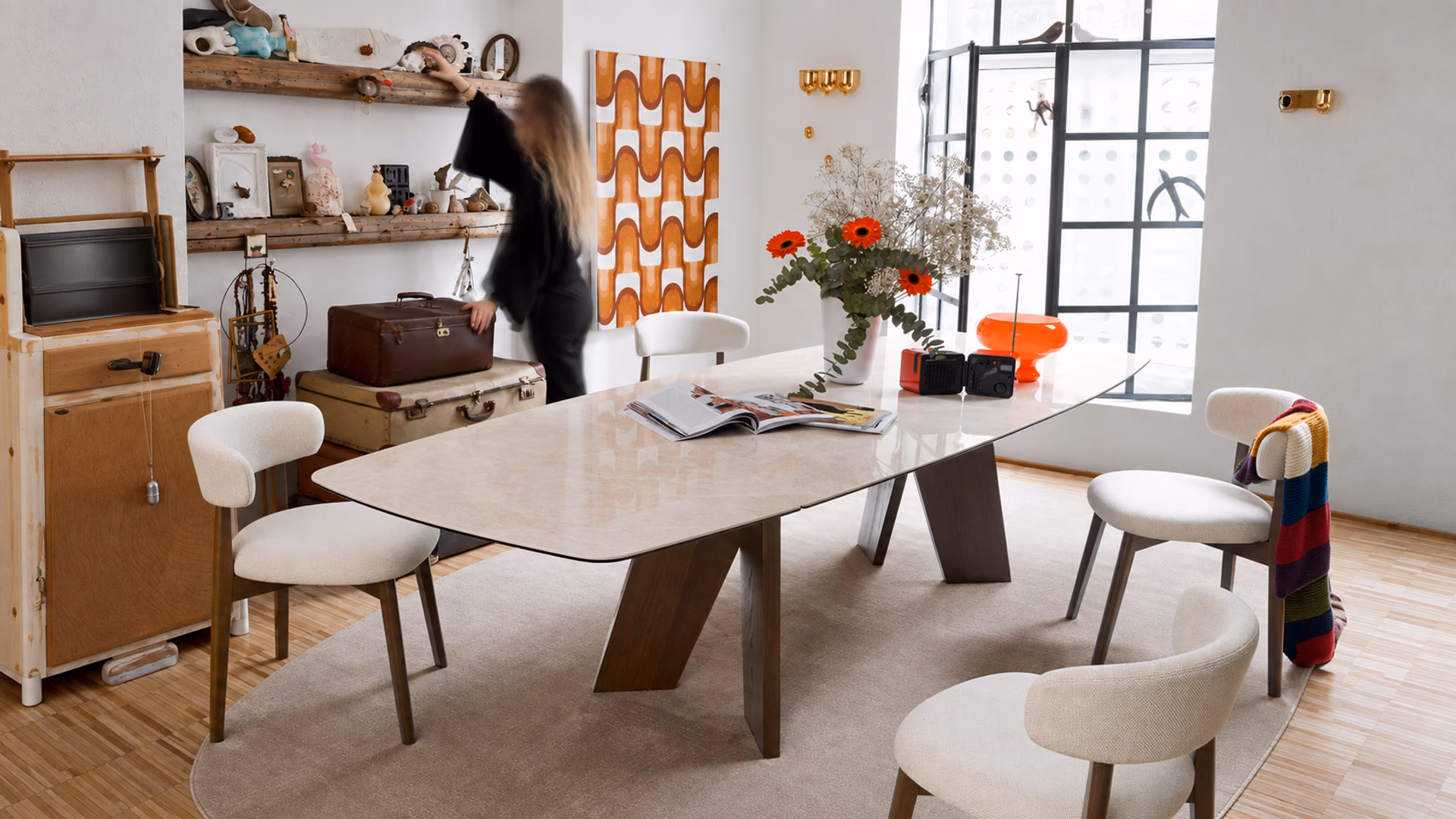 Connubia light dining table and cream upholstered chairs in an eclectic room with vintage objects.