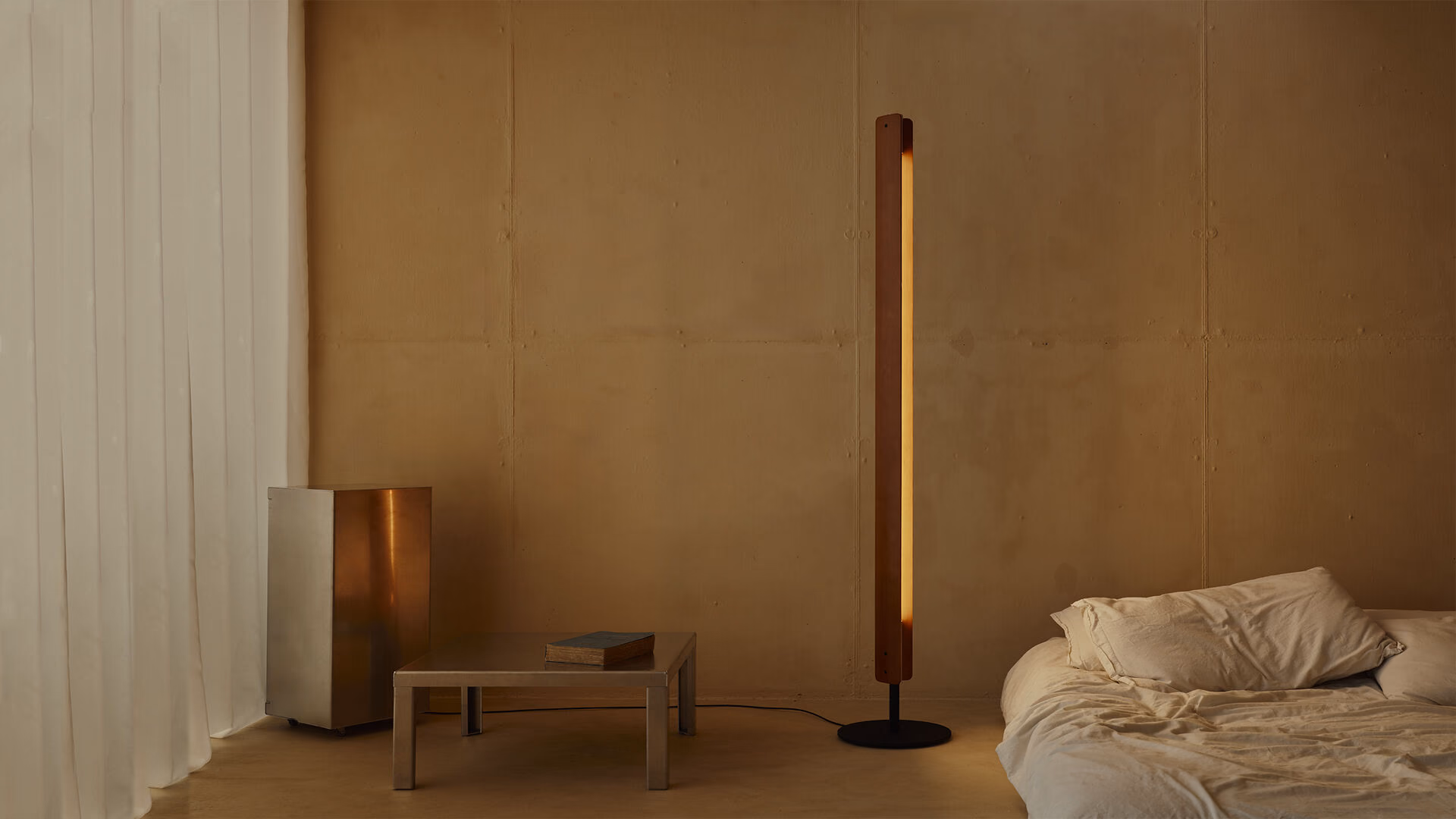 Flos Seki-Han floor lamp beside low seating in a warm minimal living room.