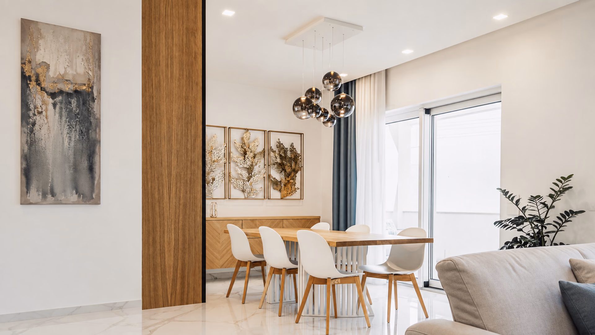 Smoked glass Lodes globe pendants above a wood dining table in a bright interior