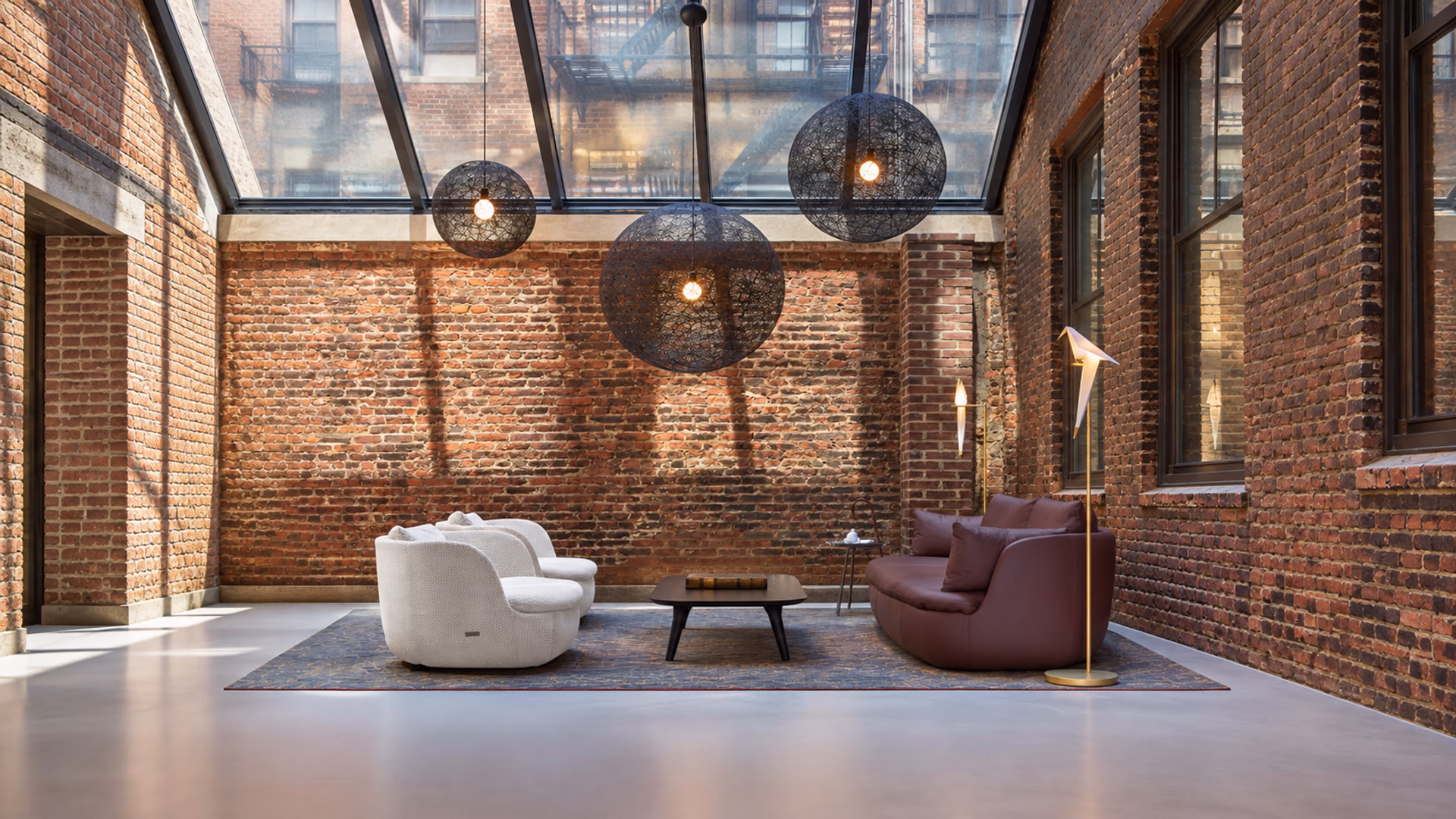 Moooi Random Light pendants above pale lounge chairs and a plum sofa in a brick loft
