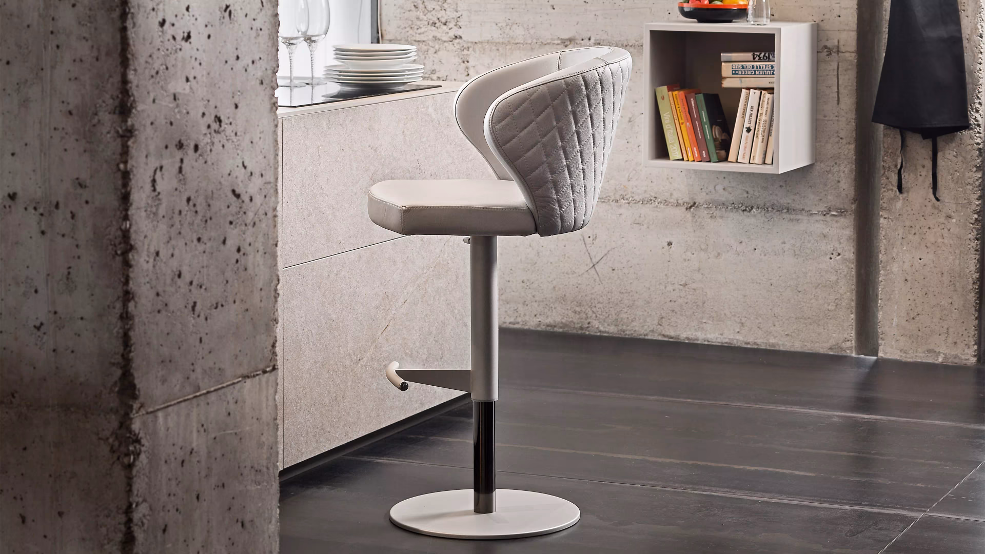 Peressini Casa upholstered swivel bar stool beside a concrete kitchen counter