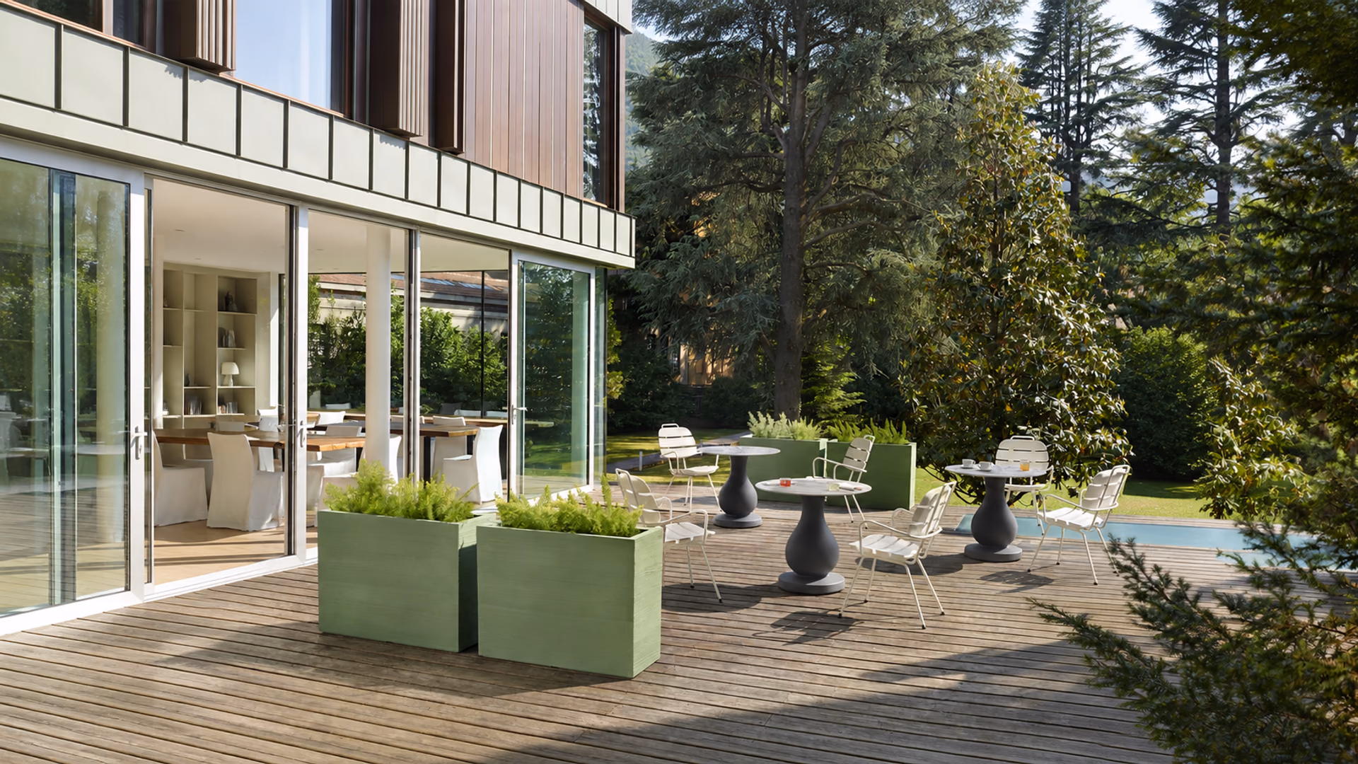 SLIDE Quadra Separé planters and sculptural café tables on a garden terrace
