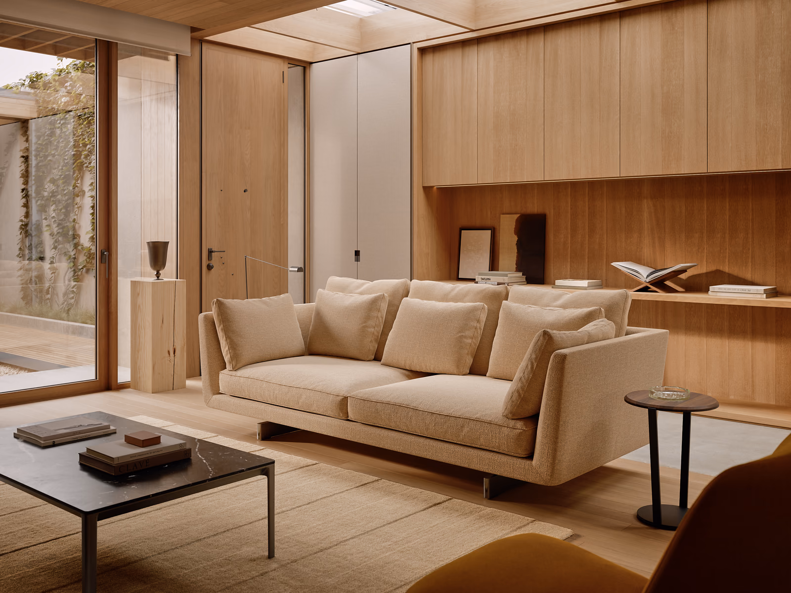 Bensen: A Savoy sofa sits beside a wood kitchen, connecting the living and dining areas.