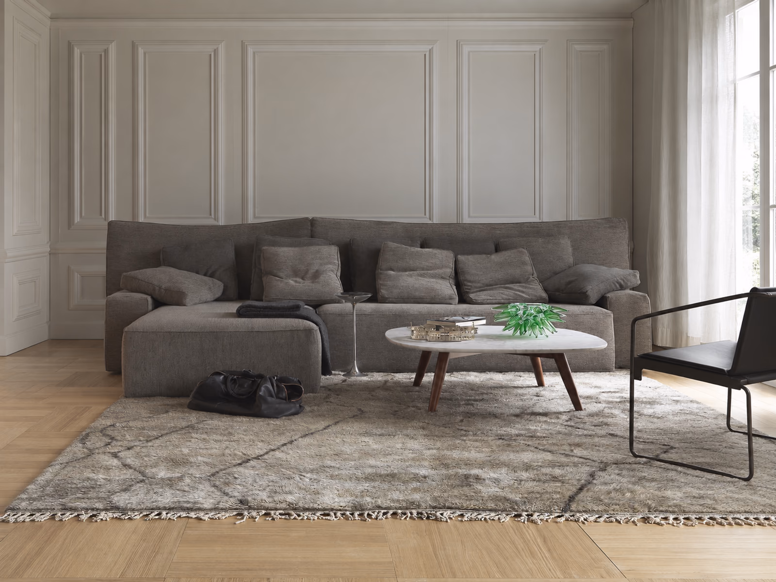 Driade: A gray WOW sofa with a chaise sits against paneled walls with a pale coffee table and black lounge chair.