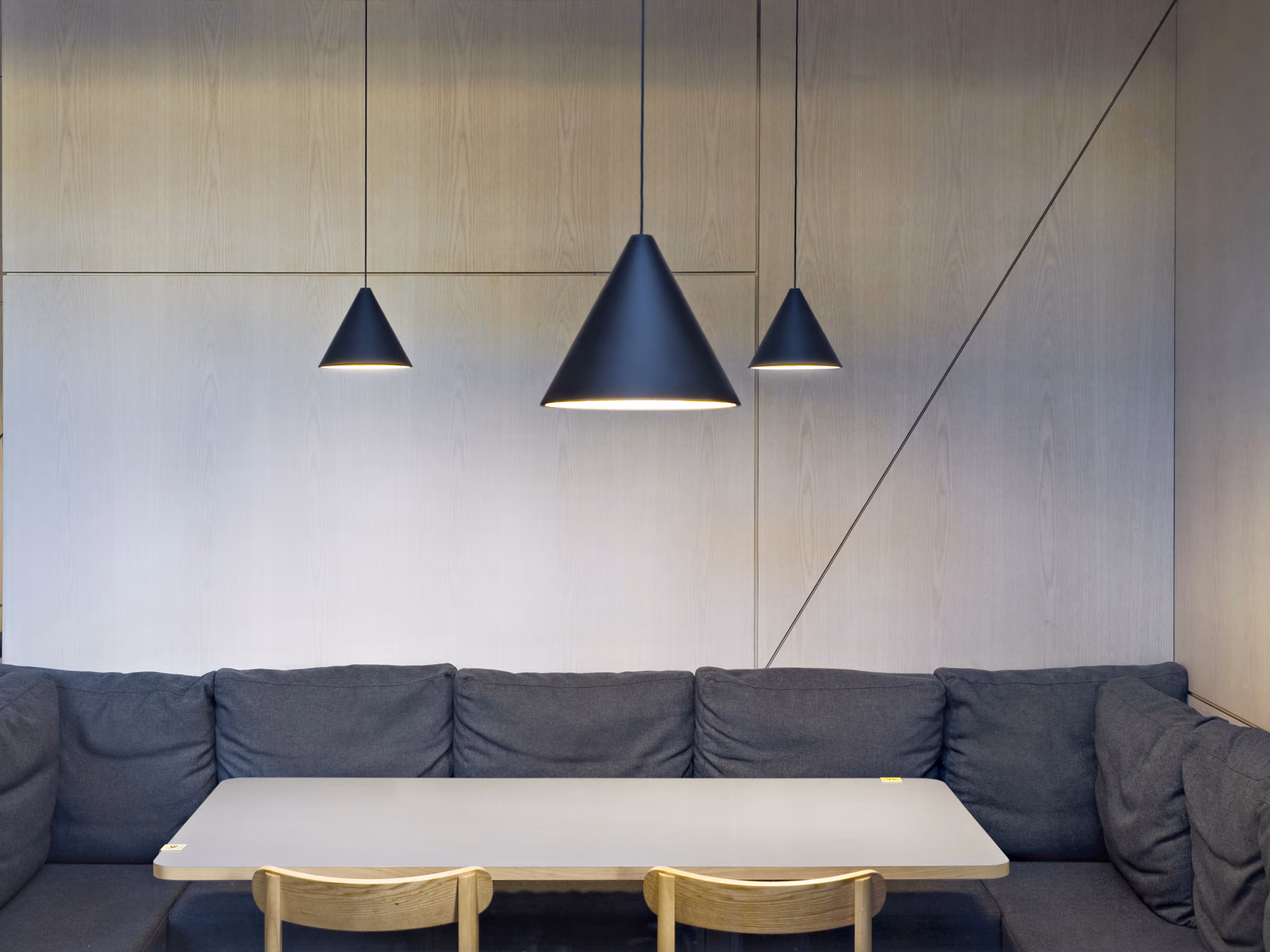 Flos: String Light pendants define a living area with upholstered sofa seating.