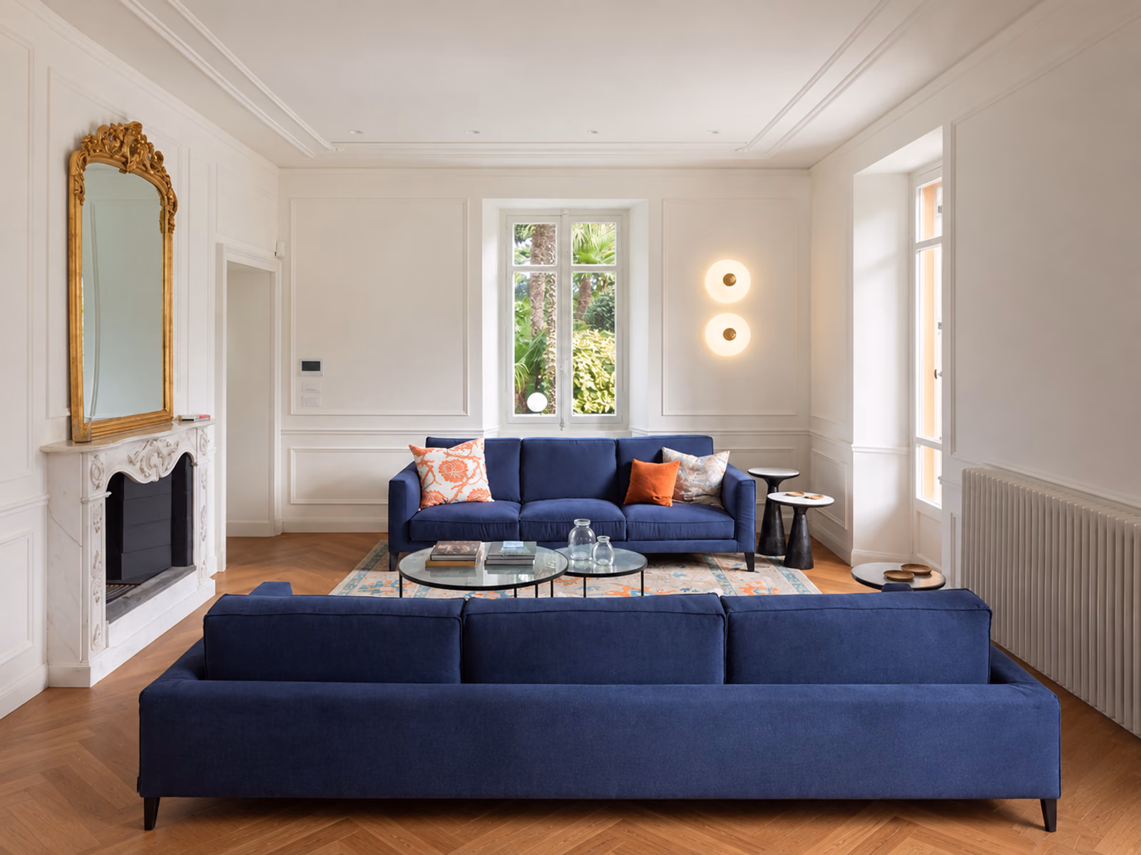 Fontana Arte: Tropico lighting complements a living room with blue upholstered sofas.
