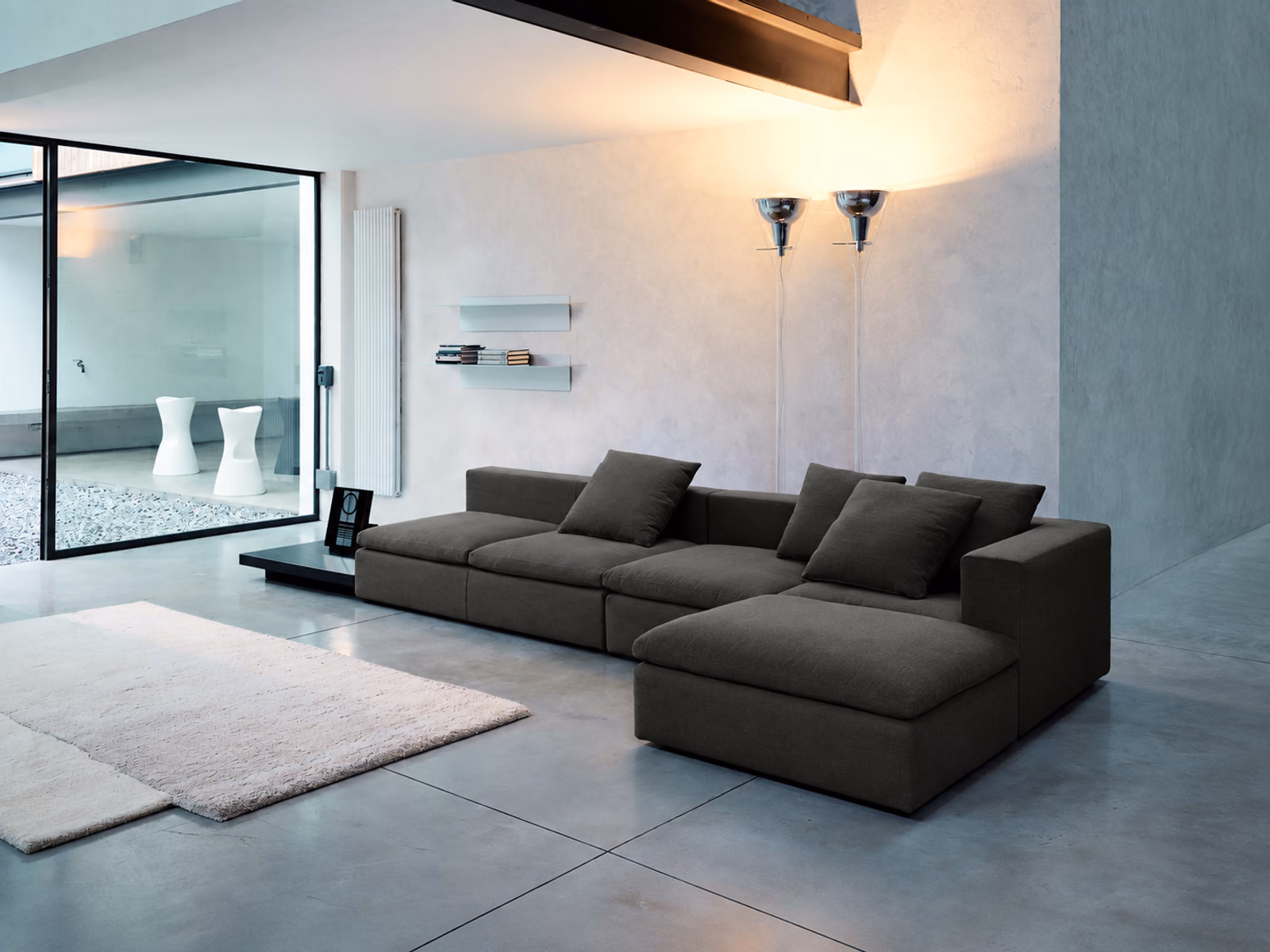 Fontana Arte: Flûte lighting accents a contemporary living room with gray modular sofa seating.