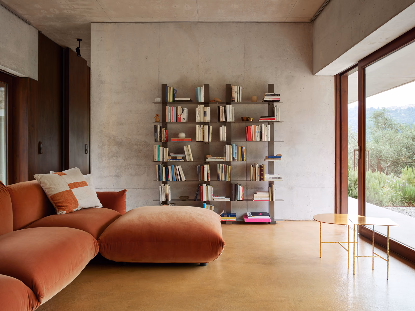Opinion Ciatti: Pacifico shelving is shown in a living room with an orange sofa.