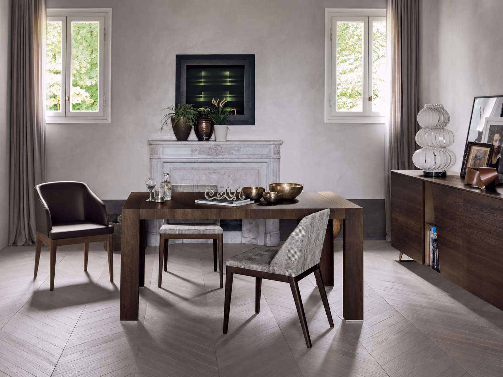 Tomasella: A wood Doppio Passo table is paired with upholstered chairs beside a fireplace and sideboard.
