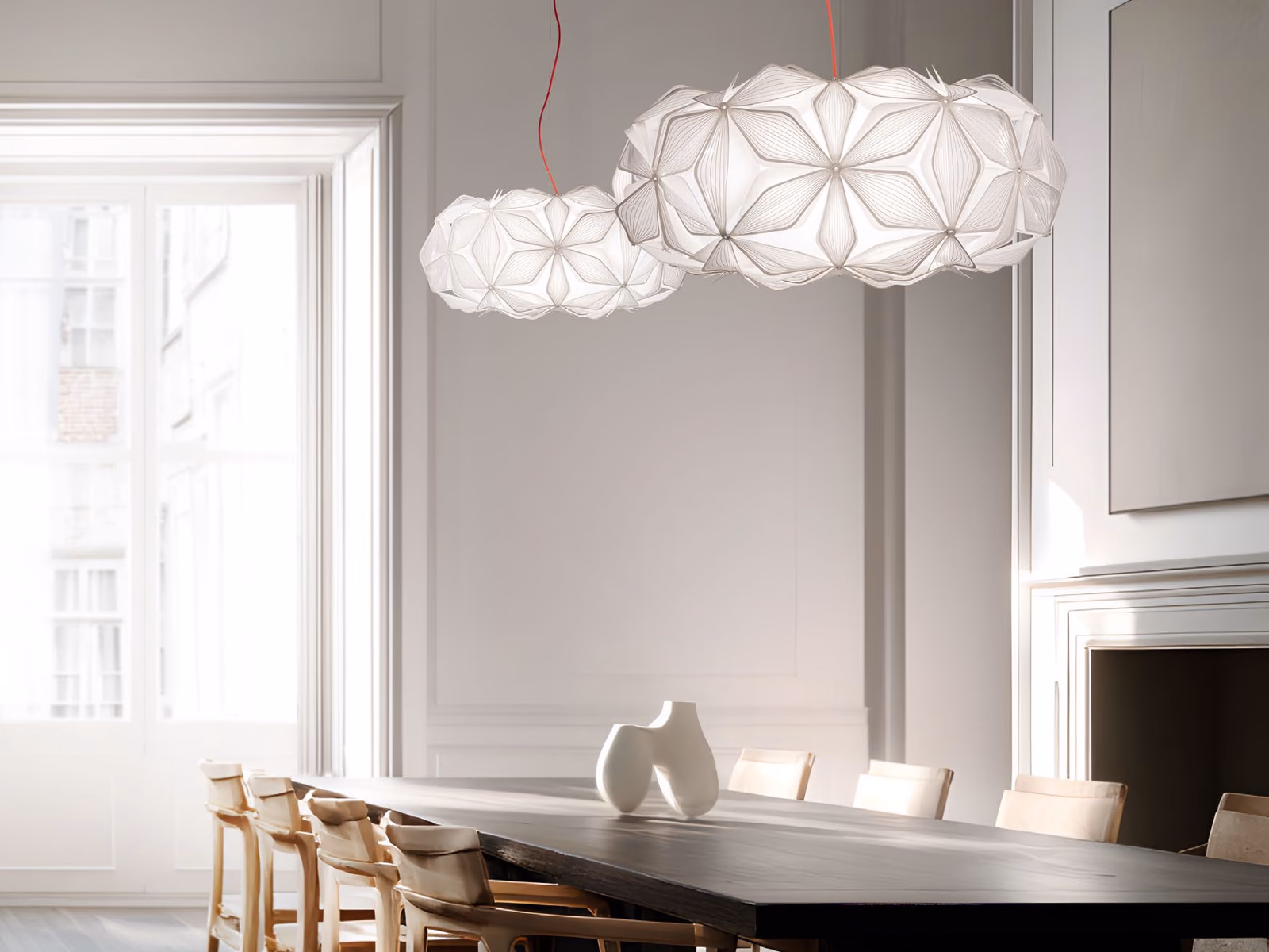 Slamp: Two white C'est La Vie pendants hang above a long dark dining table in a bright, classical room.